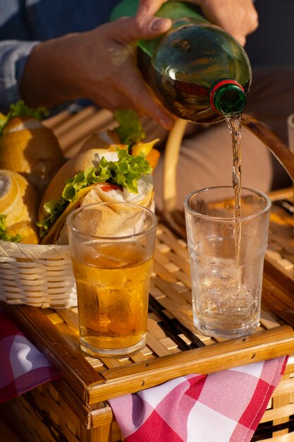 Free photo person pouring guarana drink in glass from bottle