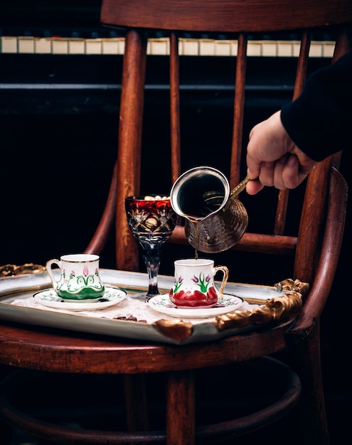 人がカップにコーヒーを注ぐ