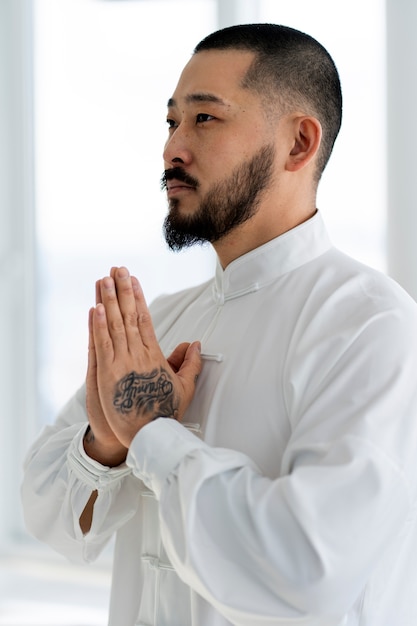 Free photo person practicing tai chi indoors