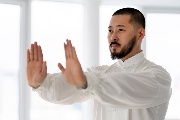 Free photo person practicing tai chi indoors