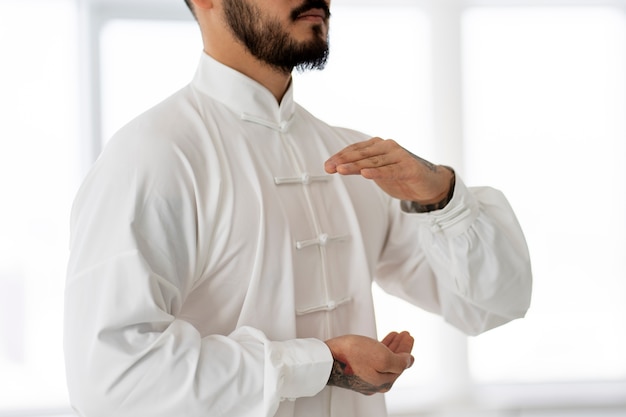 Free photo person practicing tai chi indoors