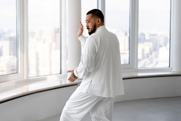 Foto gratuita persona che pratica il tai chi al chiuso