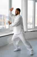 Free photo person practicing tai chi indoors