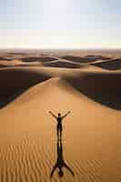 Foto gratuita persona che pratica la meditazione yoga nel deserto