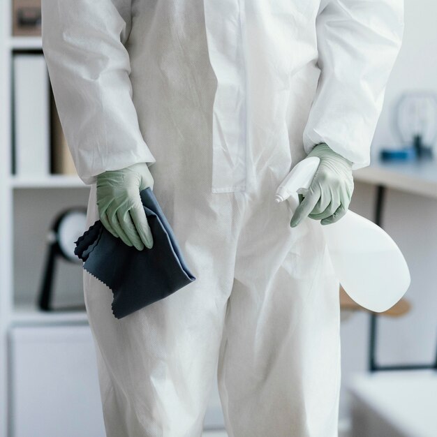 Person in protective equipment disinfecting