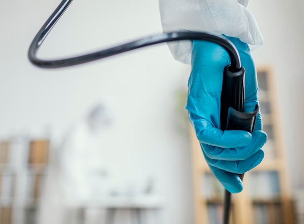 Person in protective equipment disinfecting