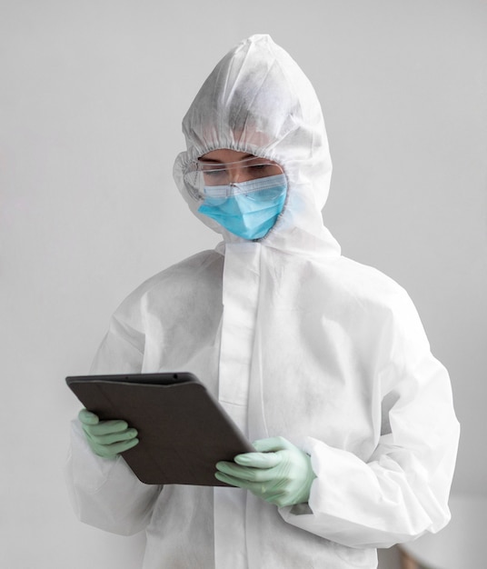 Person in protective suit looking at a tablet