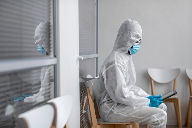 Person in protective suit looking at a tablet