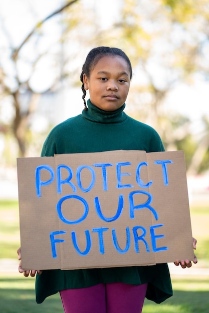 Person protesting with placard for world environment day outdoors