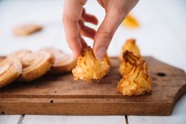 Free photo person putting cookie on wooden board