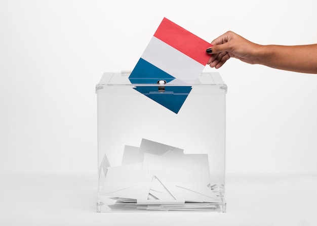 무료 사진 투표함에 프랑스 국기 카드를 넣는 사람