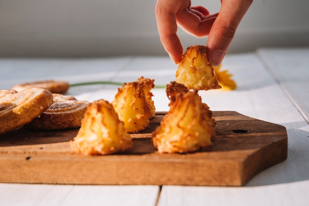 Free photo person putting small cookie on wooden board