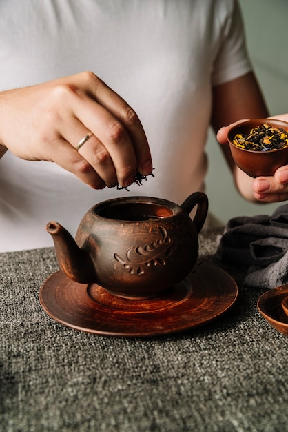 Free photo person putting tea herbs in a teapot