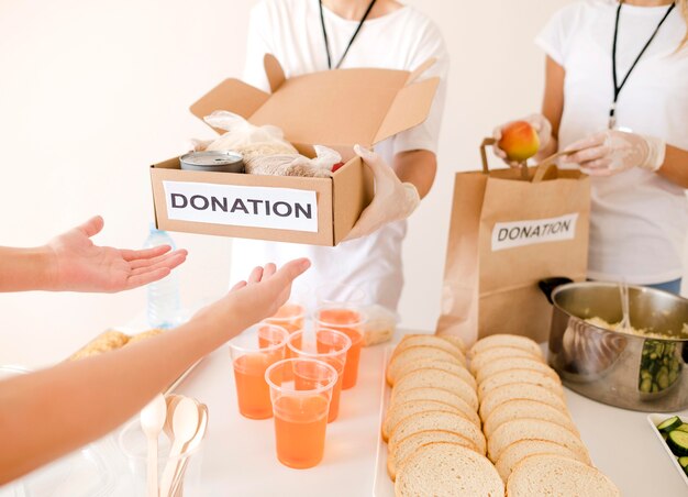 Free Photo person receiving box with donated food