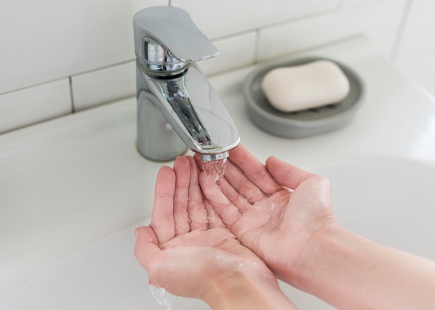 Free photo person rinsing hands before washing with soap