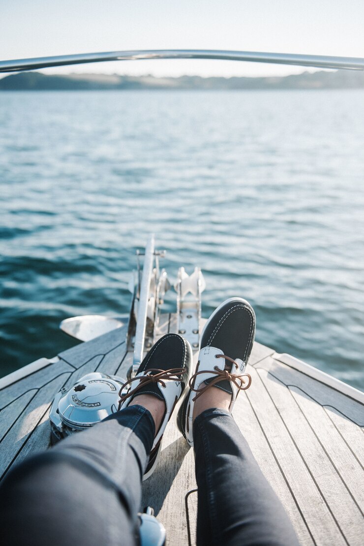 Free Photo person's feet on the boat sailing on the sea during daytime