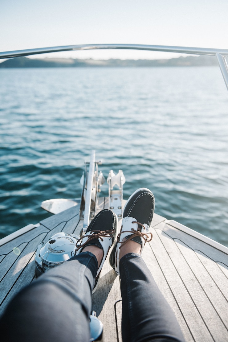 Free Photo person's feet on the boat sailing on the sea during daytime