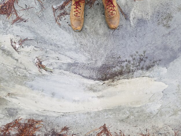 풍 화 콘크리트 바닥에 서있는 갈색 가죽 신발에 사람의 발