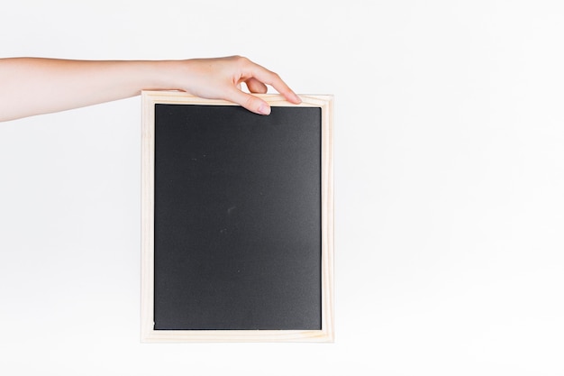 A person's hand holding black slate