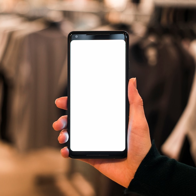 A person's hand holding mobile phone in the clothes store
