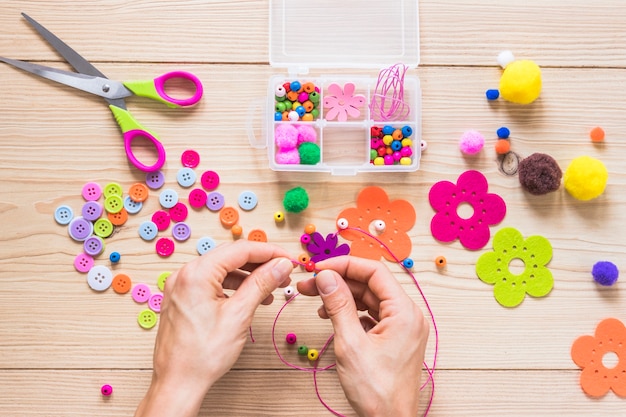 A person's hand making handmade jewelry