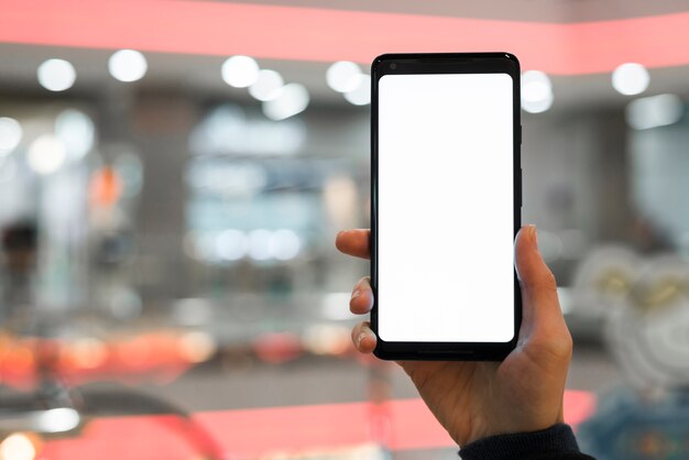 A person's hand showing mobile screen against blurred background