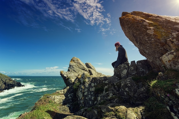 Person seated on rock formation