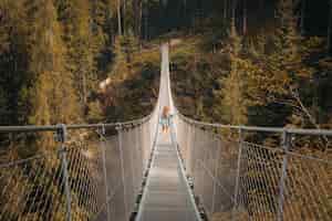 Foto gratuita persona su un ponte sospeso autoancorato