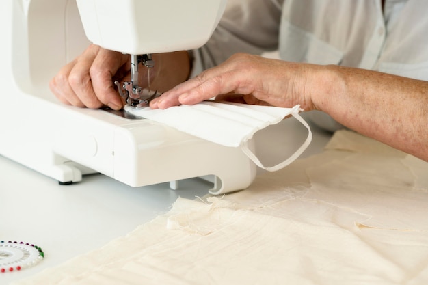 Person sewing face mask using machine