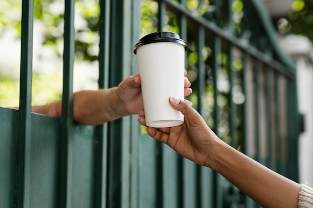 Person sharing coffee with neighbor