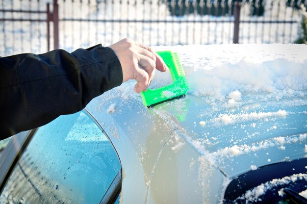 彼の車から雪かき人