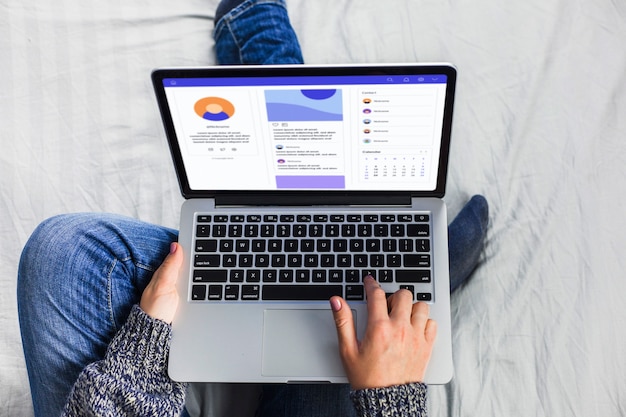 Person sitting on bed with laptop 