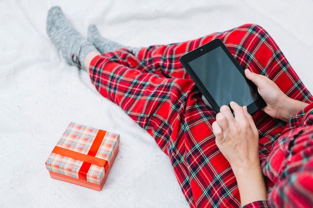 Person sitting on bed with tablet