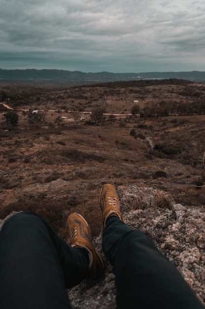 Человек сидит на горах Маллин, наслаждаясь видом на Кордову, Аргентина