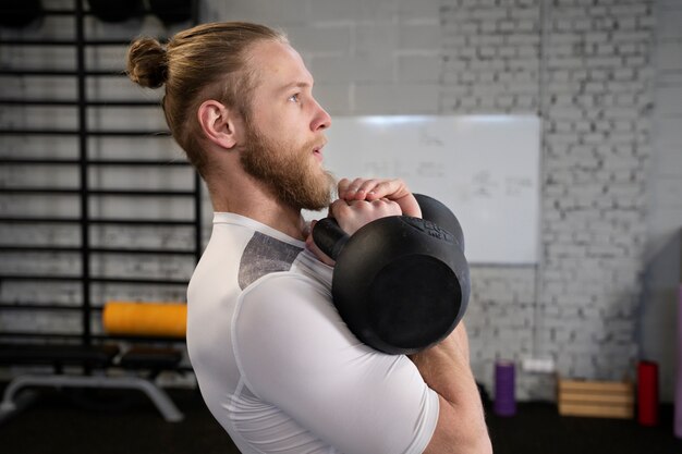 Person in sport gym using kettlebells