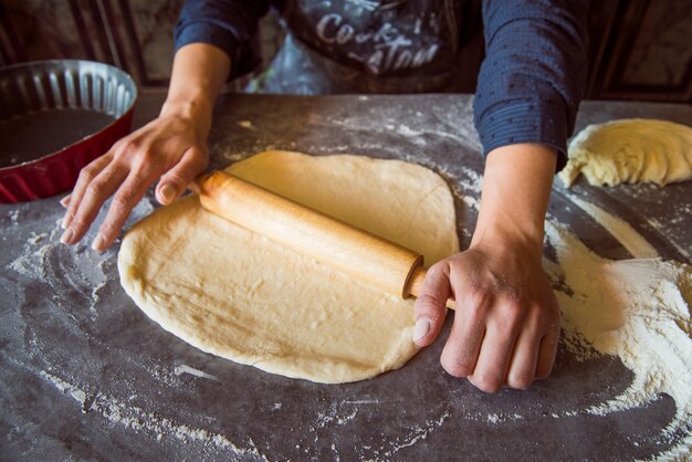 Person spreading dough with roller