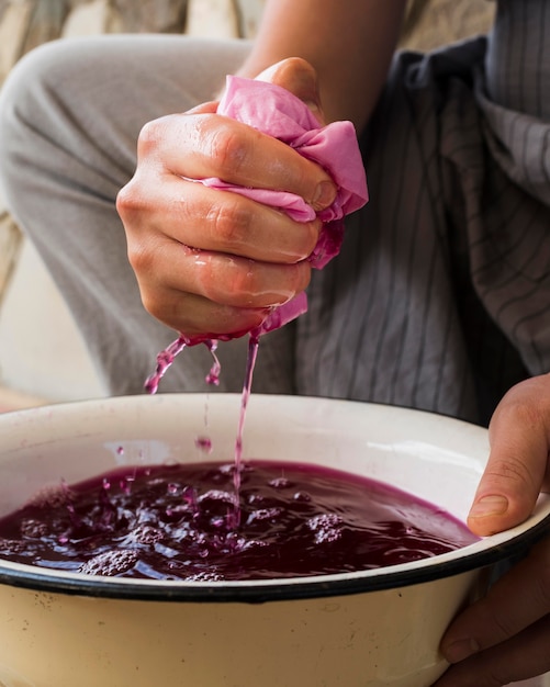 Foto gratuita persona che spreme il panno dal pigmento naturale rosa