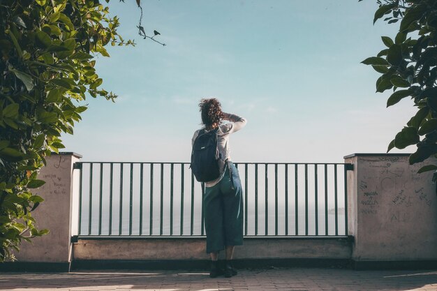 Person standing in front of fence