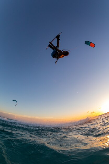 person surfing and flying a parachute at the same time in Kitesurfing