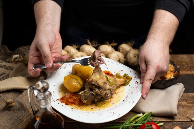 Person taking meat from stew plate