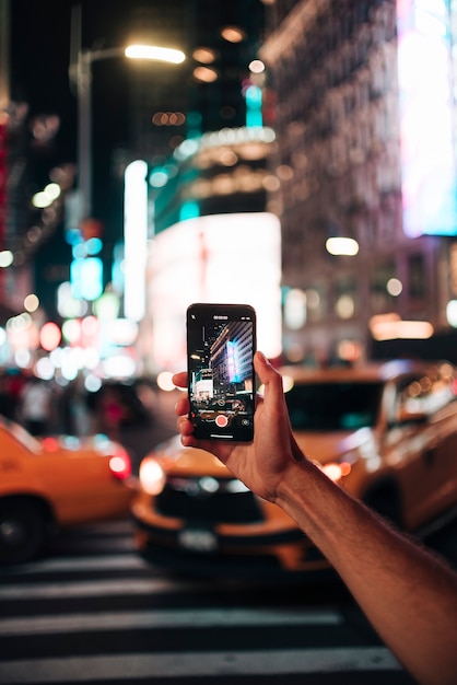 Foto gratuita persona che scatta una foto con la città vivida