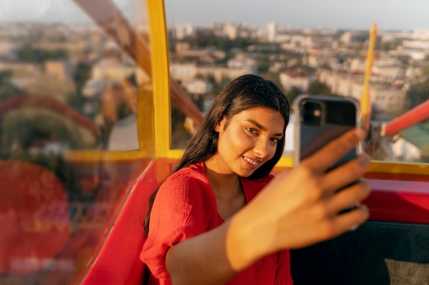 Foto gratuita persona che si fa selfie con lo smartphone mentre si trova sulla ruota panoramica