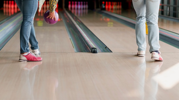 Person throwing a bowling ball in pins