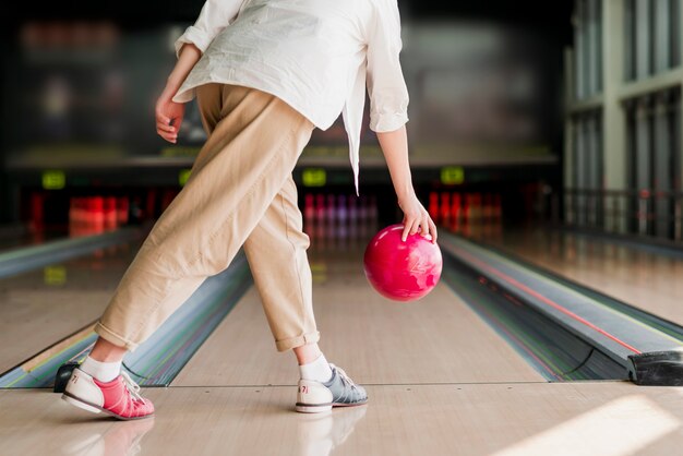 Person throwing a red bowling ball