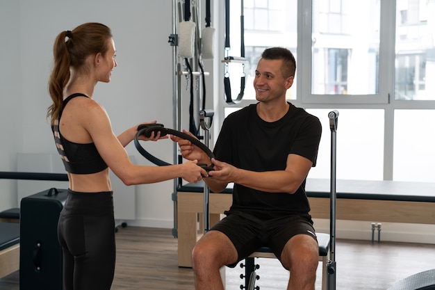 Free photo person training at the gym with a supervisor