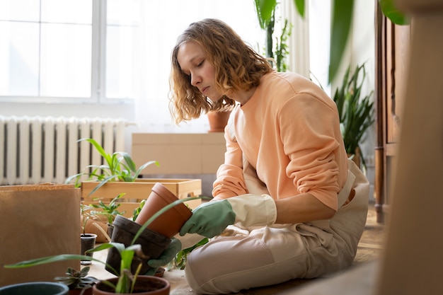 新しい鉢に植物を移植する人