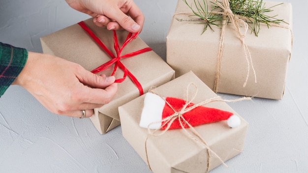 Person tying bow on big gift box 