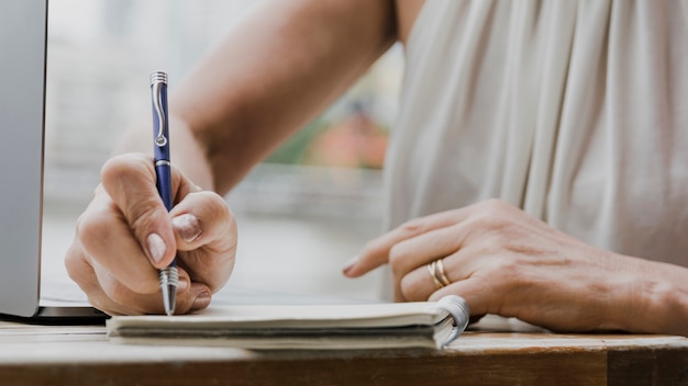 Person typing with a pen on notebook