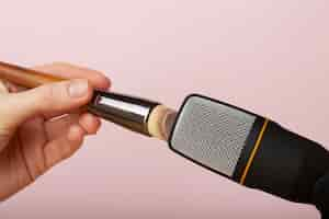 Free photo person using brush close to microphone for asmr