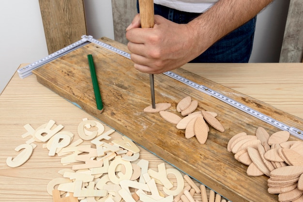 Человек, использующий плотницкий инструмент для создания деревянных фигур